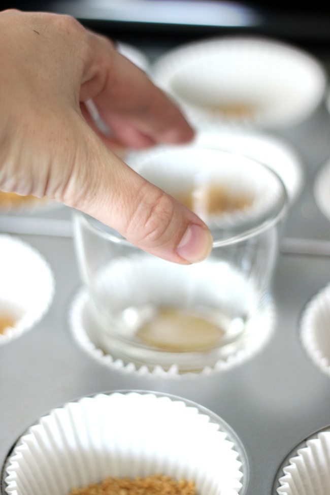 hand pressing glass into muffin tin