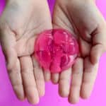 Hands holding pink jelly soap.
