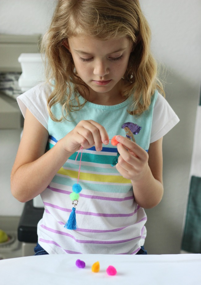 Make a pom pom key chain to accessorize your back pack this year! With a printable name tag to color, it is a fun and personalized way to label your bag!