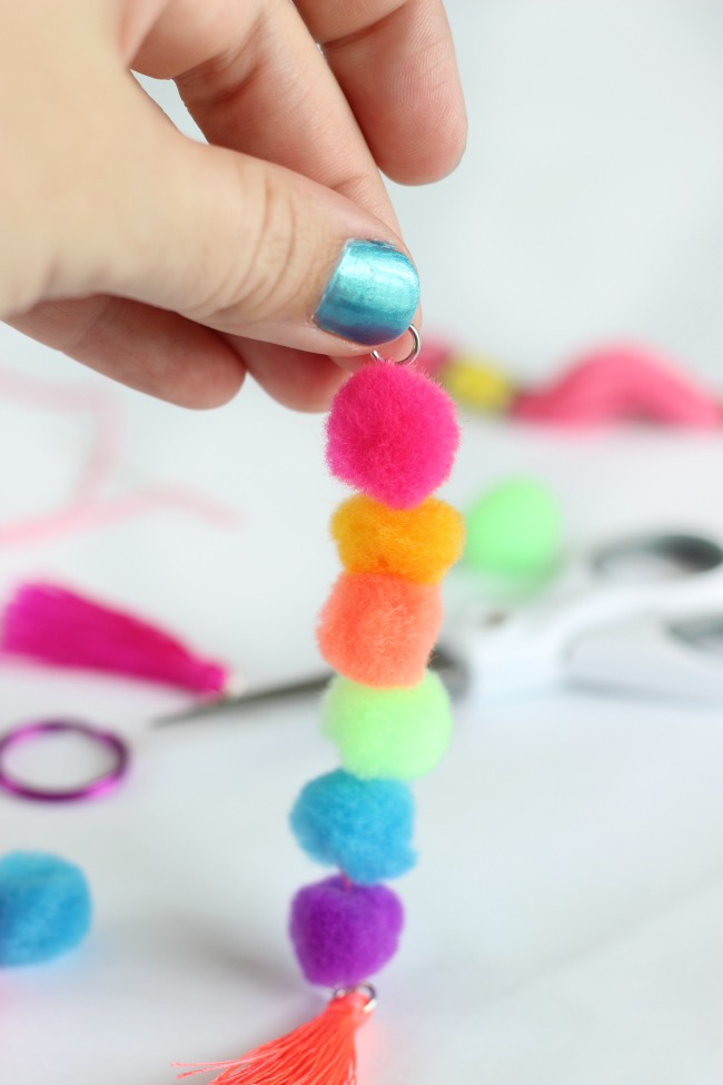 Make a pom pom key chain to accessorize your back pack this year! With a printable name tag to color, it is a fun and personalized way to label your bag!