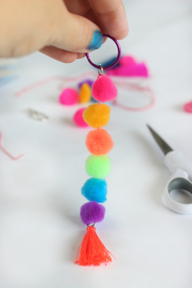 Make a pom pom key chain to accessorize your back pack this year! With a printable name tag to color, it is a fun and personalized way to label your bag!