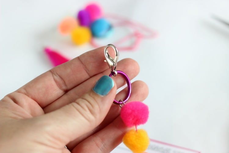 Make a pom pom key chain to accessorize your back pack this year! With a printable name tag to color, it is a fun and personalized way to label your bag!