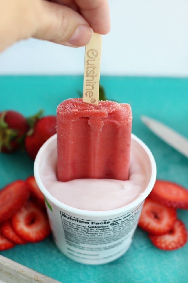 These real strawberry fruit bars are dipped in low-fat strawberry banana yogurt and topped with a fresh strawberry slice. It's like a smoothie on a stick!