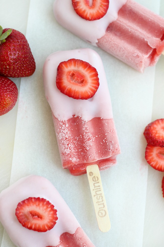 These real strawberry fruit bars are dipped in low-fat strawberry banana yogurt and topped with a fresh strawberry slice. It's like a smoothie on a stick!