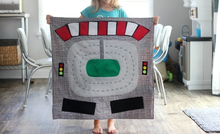 Make a race track play mat to inspire creative play in your home! This double sided mat is soft to sit on and folds up for easy storage. The perfect place to play with your favorite cars and trucks!
