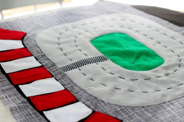 Make a race track play mat to inspire creative play in your home! This double sided mat is soft to sit on and folds up for easy storage. The perfect place to play with your favorite cars and trucks!