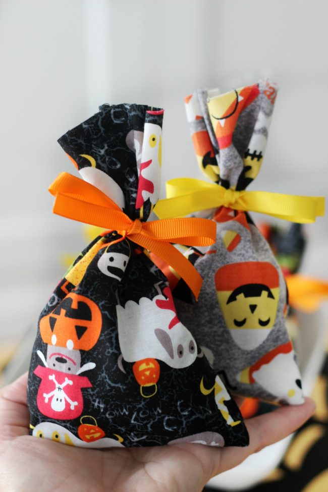 These treat bags are easy to make and fun to fill with candy. Use them as mini BOO kits and doorbell ditch on Halloween! A 2-minute sewing tutorial!