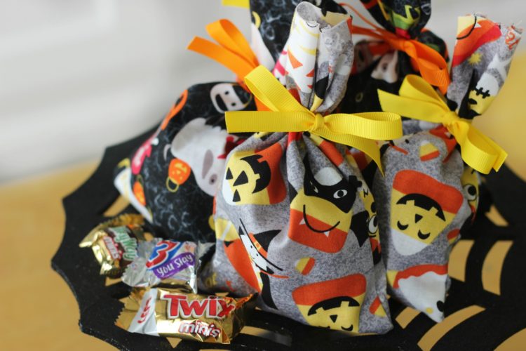 These treat bags are easy to make and fun to fill with candy. Use them as mini BOO kits and doorbell ditch on Halloween! A 2-minute sewing tutorial!