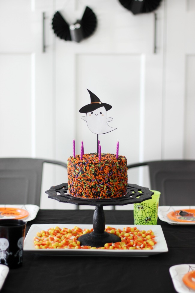 small halloween sprinkles cake on table with black table cloth