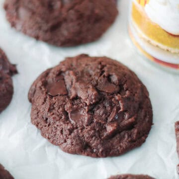 Chocolate pumpkin cookies on parchment paper next to can of pumpkin puree.