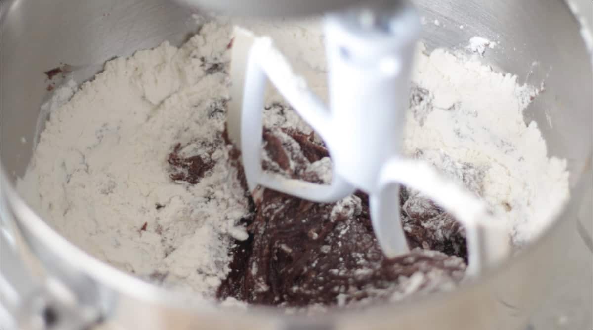 Flour being mixed into pumpkin cookie dough.