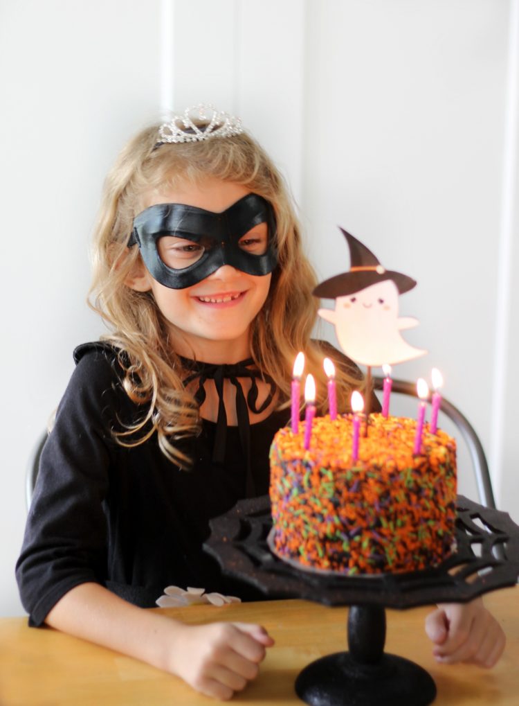 child with cake and lit candles for birthday