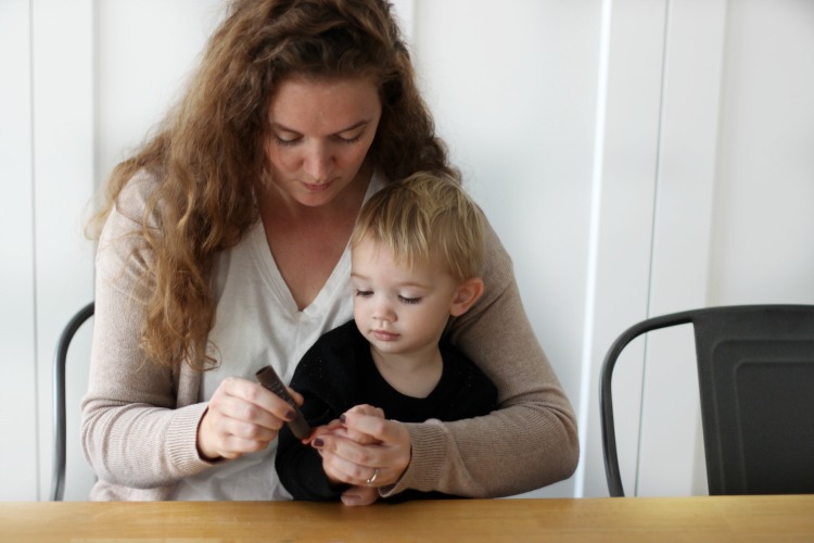 mom and toddler making reindeer thumbprint ornament