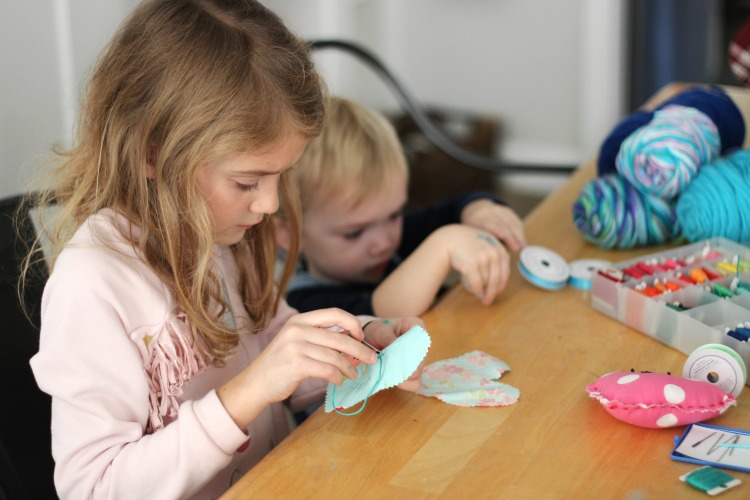 children hand stitching a project