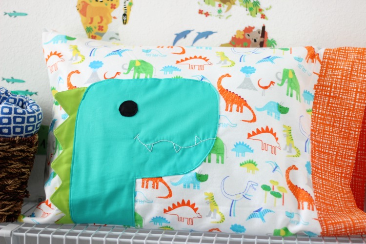 A free dinosaur pillowcase pattern available in travel, kid, or standard size! So cute and easy to customize. A great beginner sewing project.