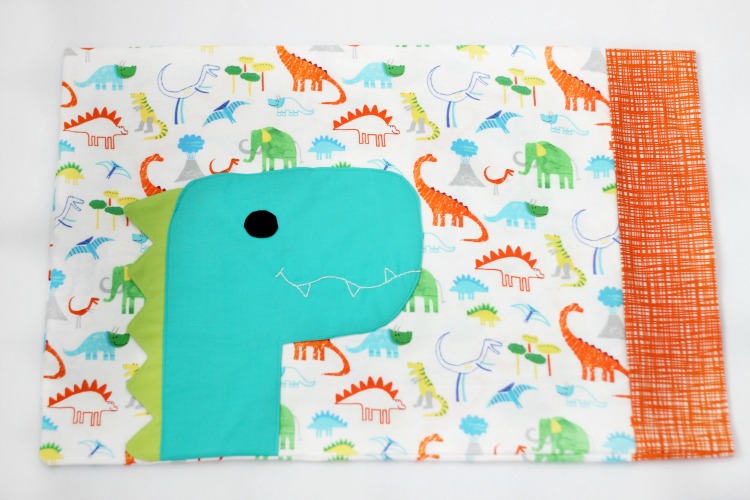 A free dinosaur pillowcase pattern available in travel, kid, or standard size! So cute and easy to customize. A great beginner sewing project.