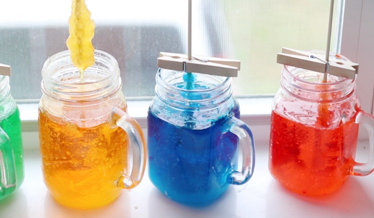 3 jars of colored syrup in jars sitting on window sill