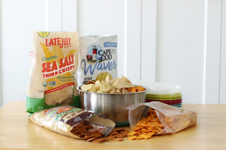 chips and pretzels on table with bowl filled with mixed snacks