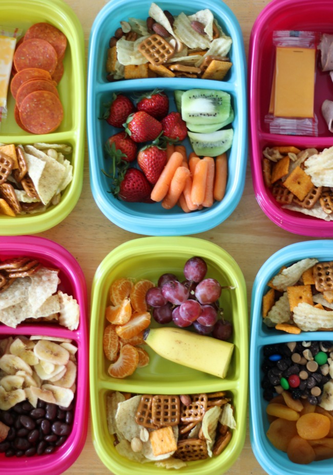 6 snack containers filled with a variety of sweet savory and fresh fruit snacks