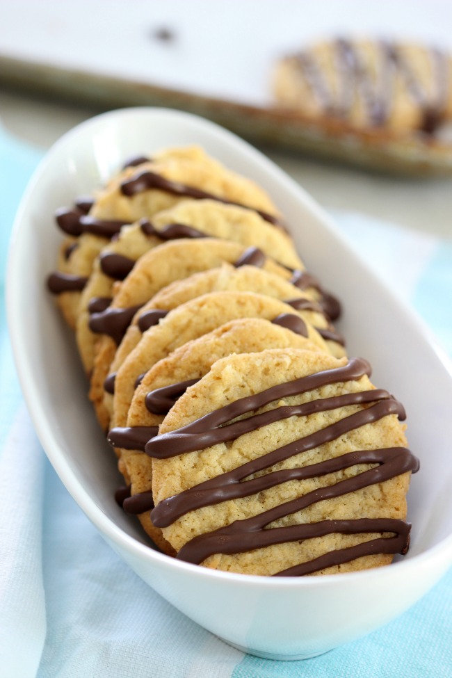 chocolate drizzled crispy coconut cookies on serving platter