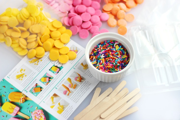 cupcake topper kit ingredients, candy melts, sprinkles, popsicle sticks on table