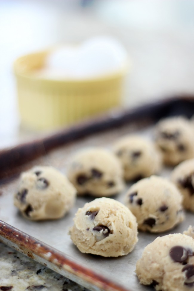 frozen cookie dough balls on baking sheet