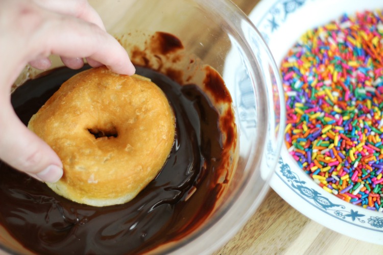 dipping donut in chocolate glaze