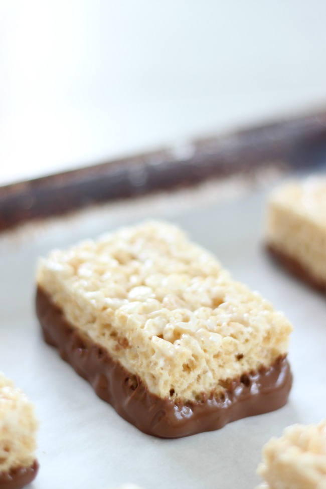 chocolate dipped Rice Krispies treat on baking sheet lined in parchment paper