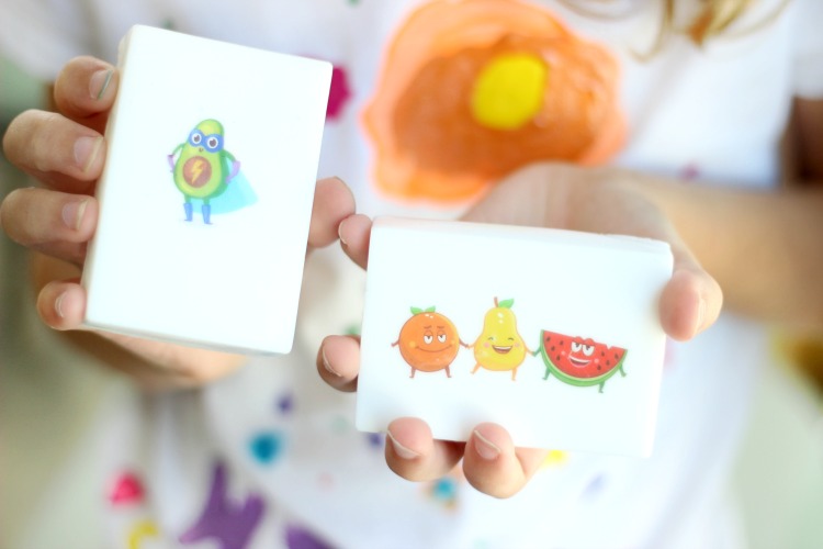 child holding two bars of soap