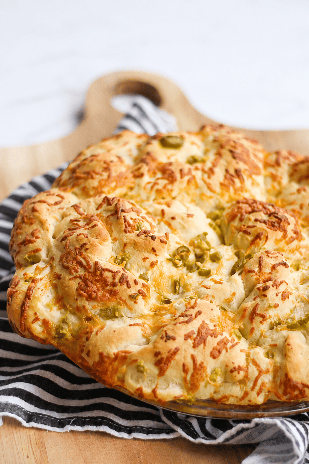 Loaf of jalapeno cheese bread on cutting board.