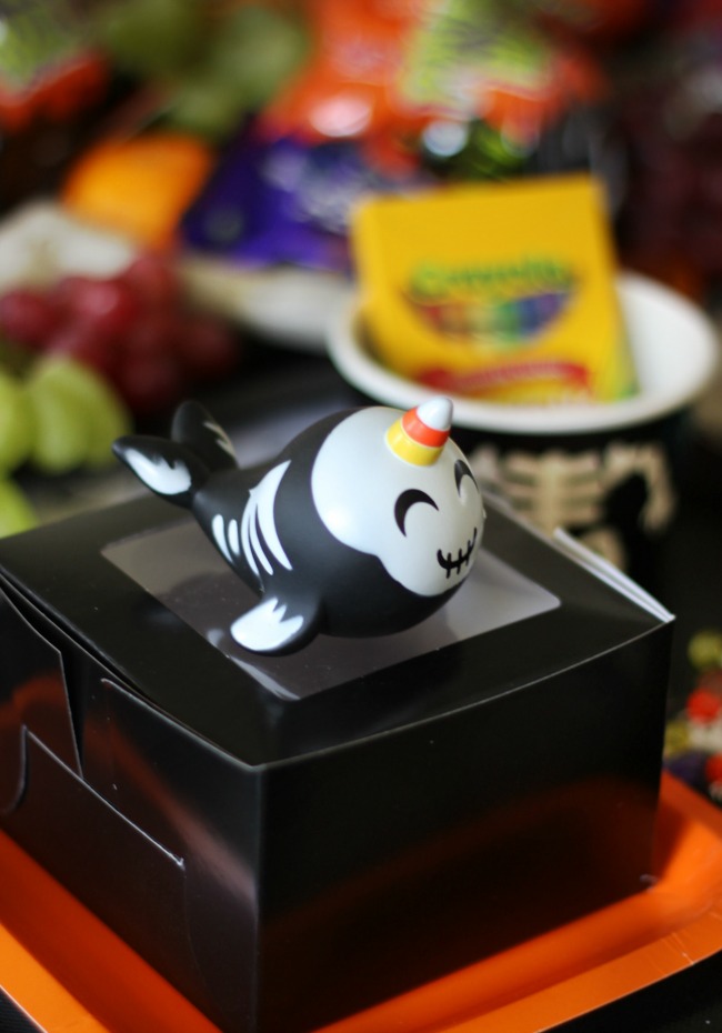 black treat box with Halloween narwhal toy on top for party favor