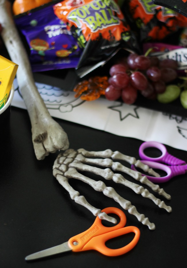black table cloth with skeleton hand and craft scissors