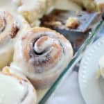 Glass baking dish with frosted cinamon rolls.