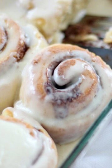 Glass baking dish with frosted cinnamon rolls.