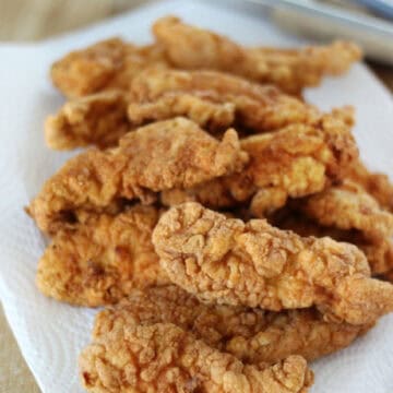 Plate lined with paper towels and crispy chicken tenders.