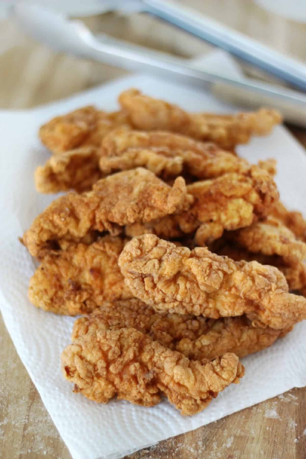 Plate lined with paper towels and crispy chicken tenders.