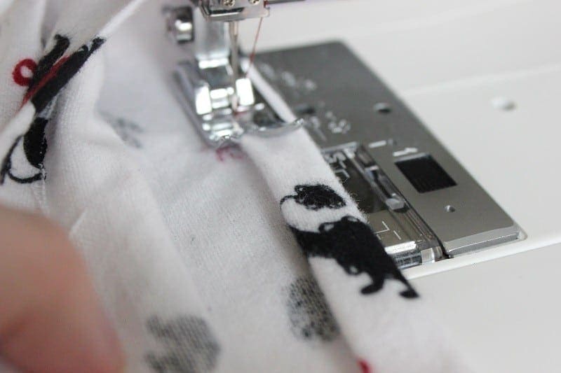 Bottom of pants being hemmed on sewing machine.