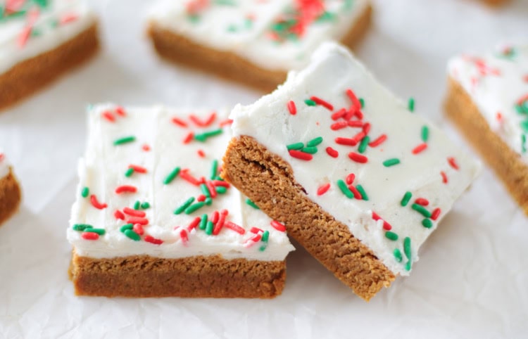 gingerbread cookie bars with frosting and sprinkles cut into squares