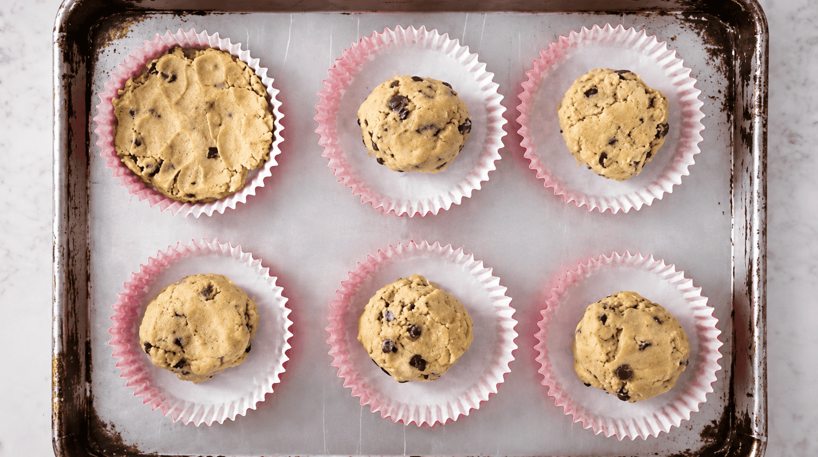 Cookie dough balls in baking liners.