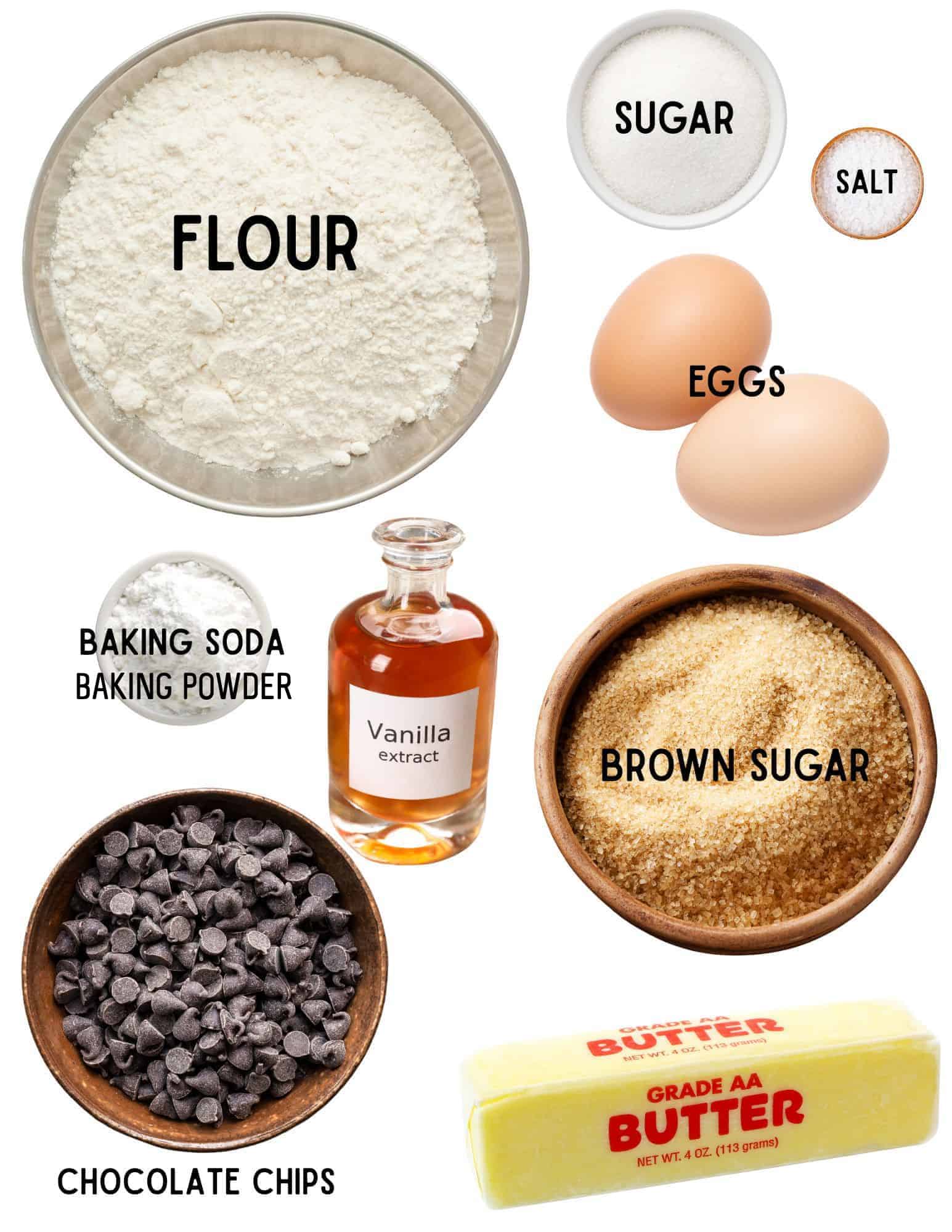 Bowls of flour, sugar, salt, baking soda and baking powder with two eggs, brown sugar, stick of butter, bowl of chocolate chips and bottle of vanilla.