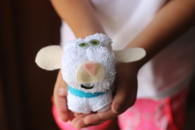 child holding wash cloth lamb