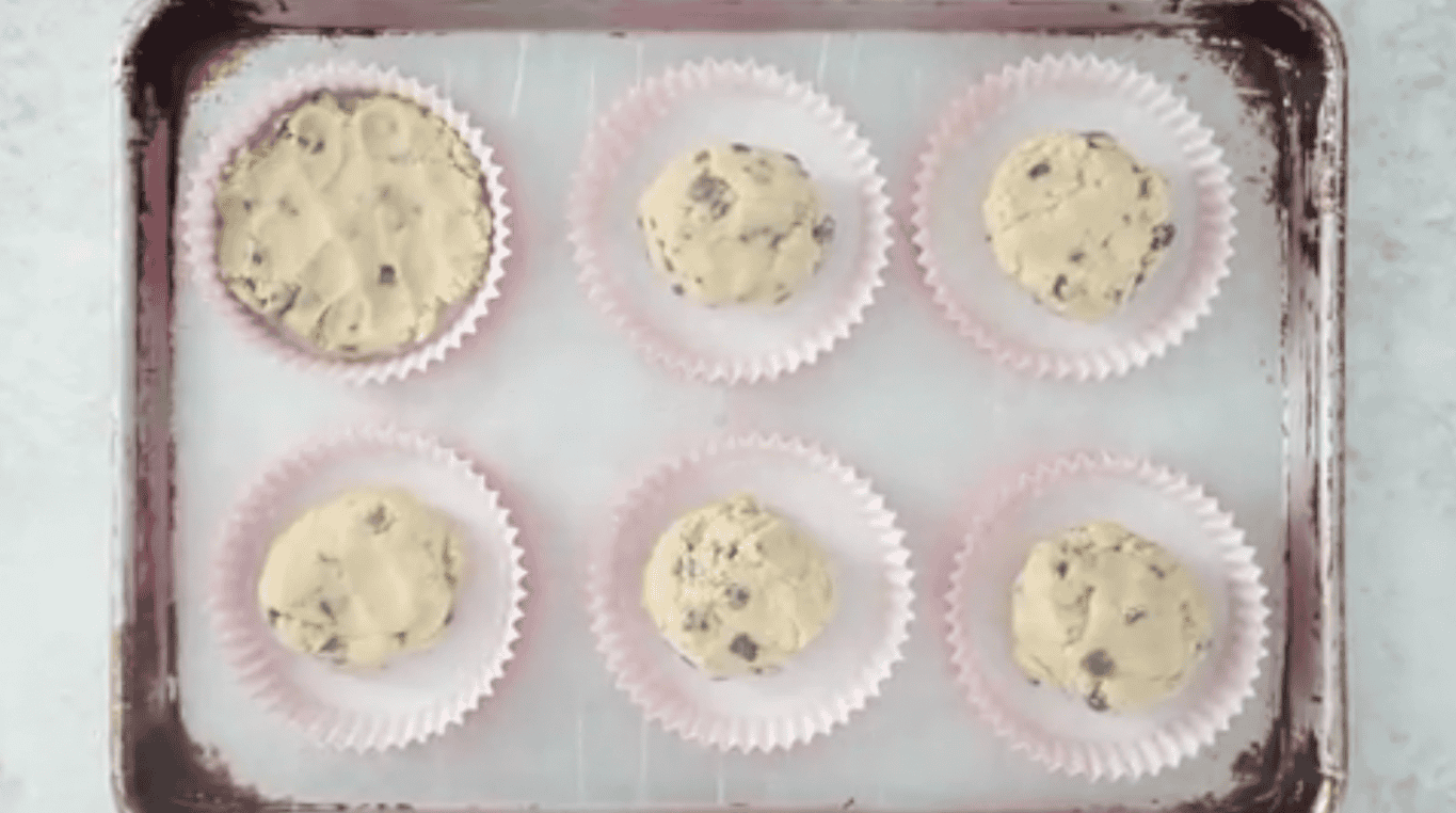Baking sheet with baking liners of cookie dough.
