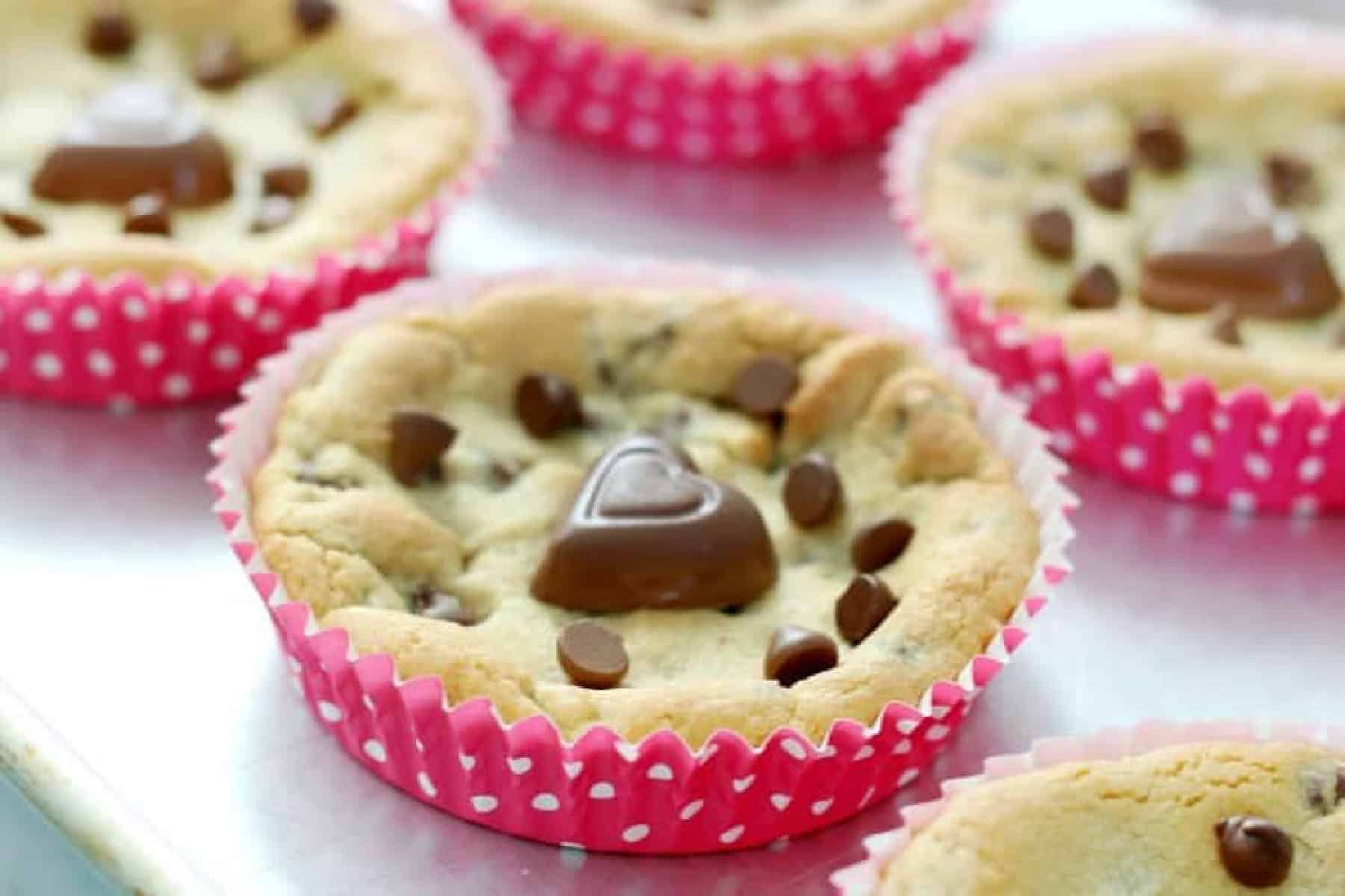 Deep dish cookies in liners on a baking dish.