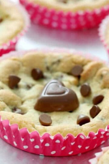 Deep dish chocolate chip cookies in pink baking liners.
