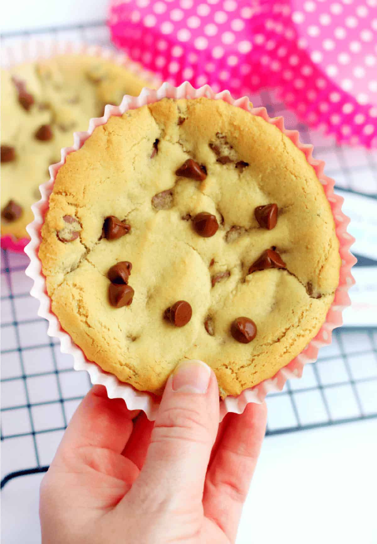 Hand holding deep dish chocolate chip cookie.