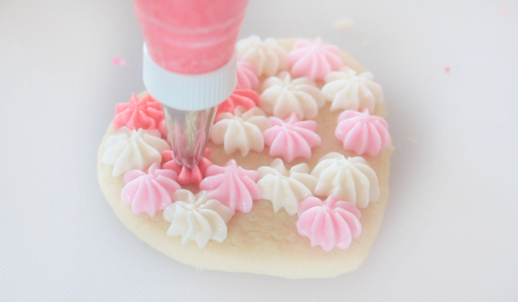 frosting tip #21 covering heart sugar cookie