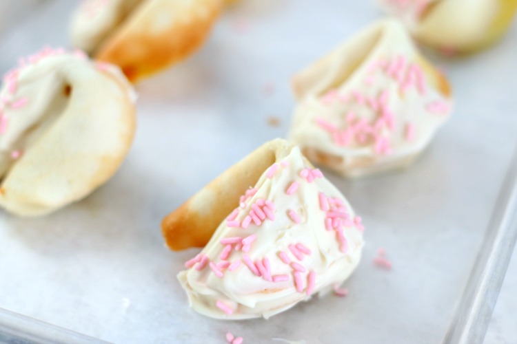 white chocolate dipped fortune cookies on baking sheet
