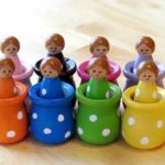 wooden peg dolls painted in rainbow colors
