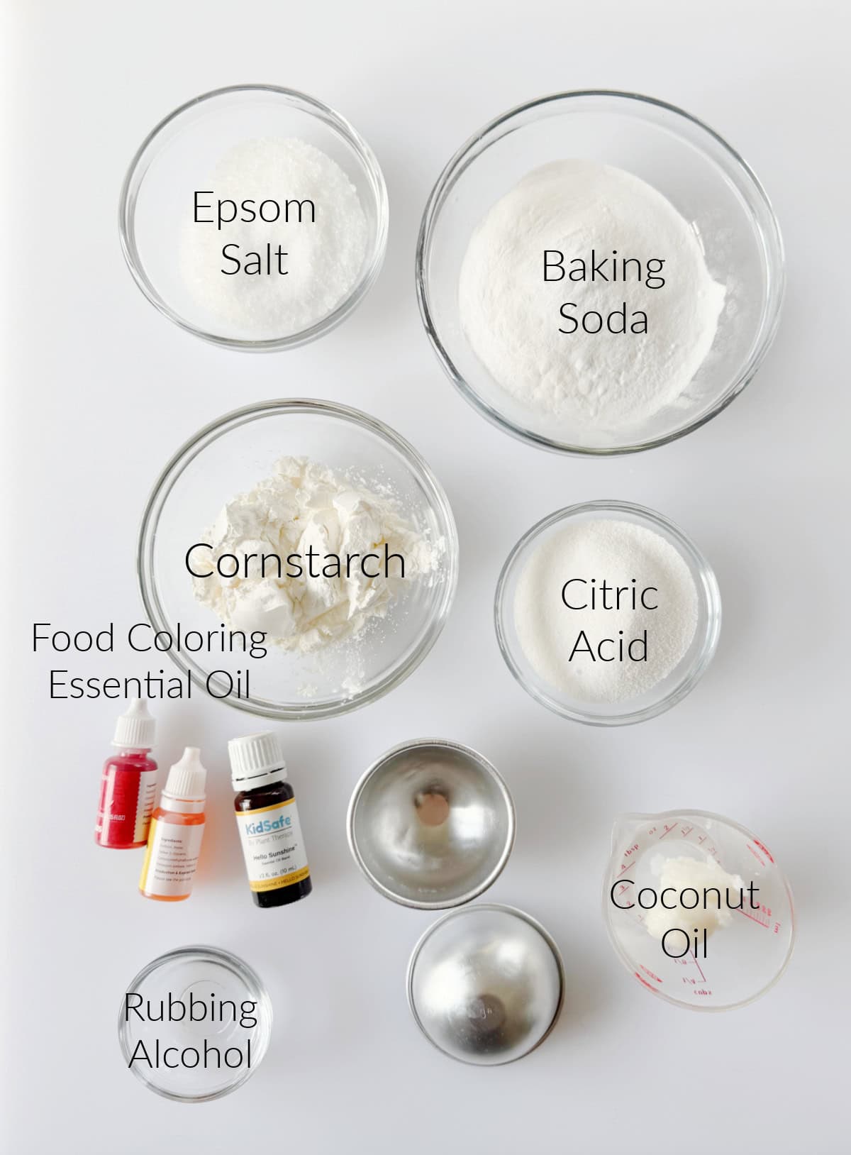 Bowls of cittic acid, baking soda, cornstarch, epsom salt, rubbing alcohol and bottles of food coloring and essential oil.