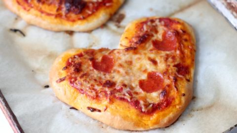 mini heart pizzas on parchment paper